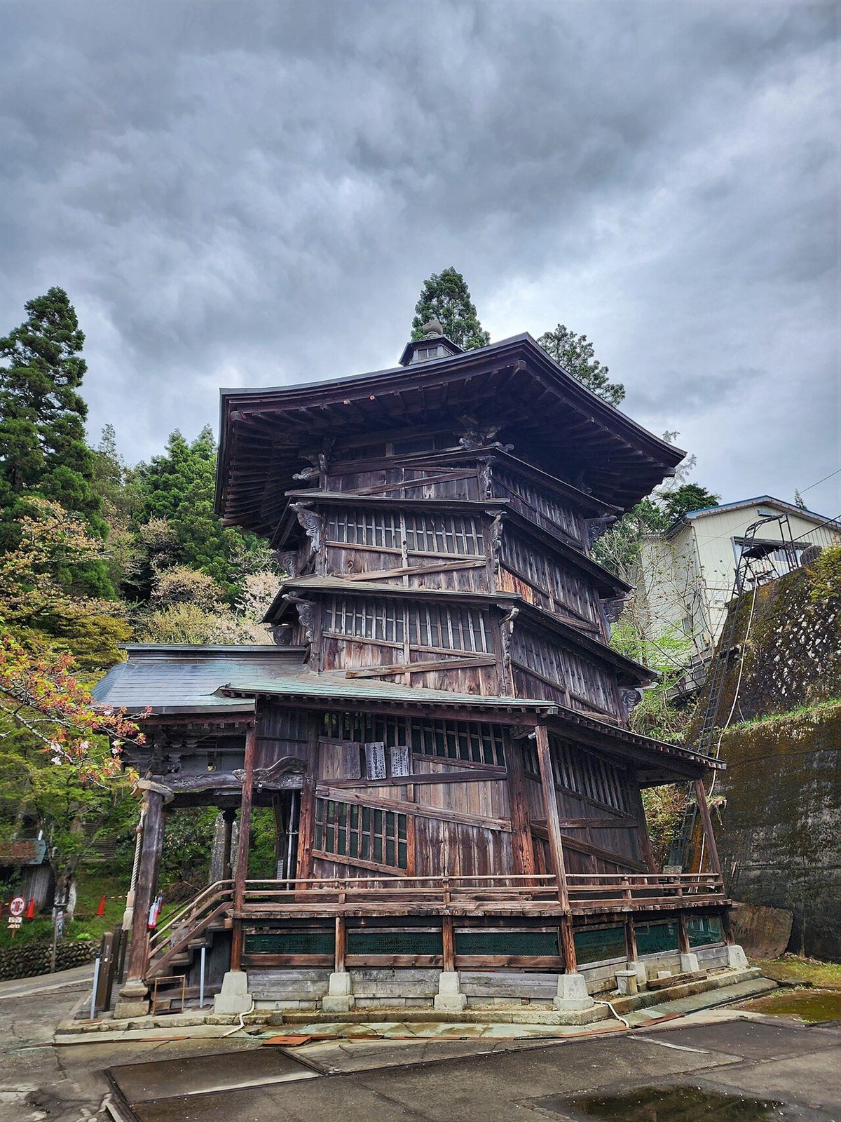 山あいにたつ、屋根が幾重にも重なる六角三層の木造のさざえ堂