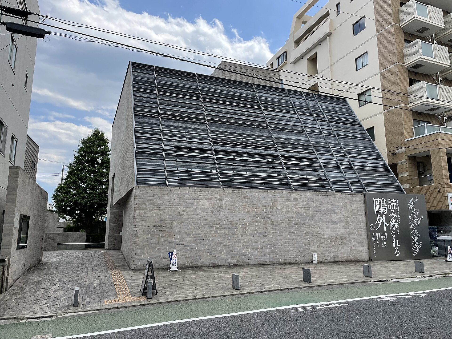 灰色のれんがの壁と、斜めに傾いた格子状の外壁をもつ森鴎外記念館の外観