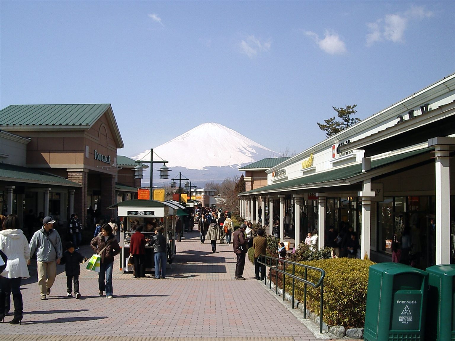 店が並ぶ通りの先に、雪をかぶった富士山が見える御殿場プレミアム・アウトレット