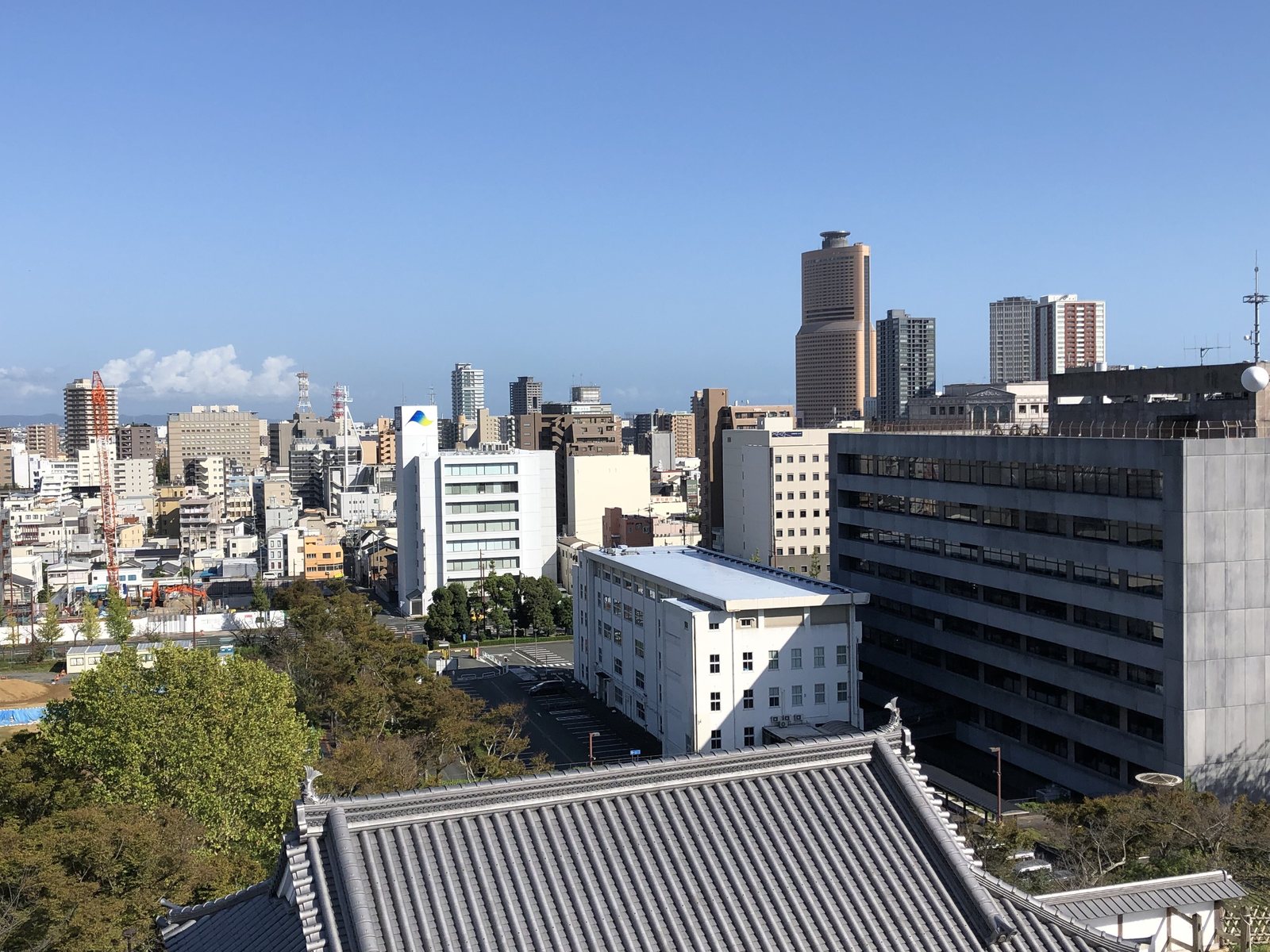 浜松城の屋根越しに見える、浜松の市街とビル群