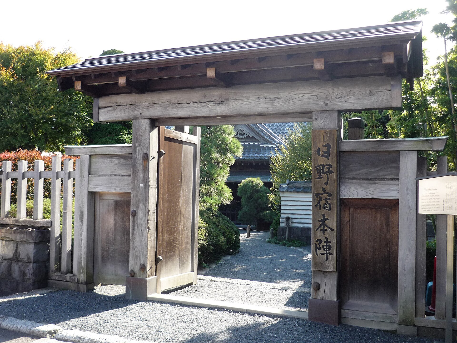 木の柱に「日野宿本陣」の札がかかった、板の扉のある門