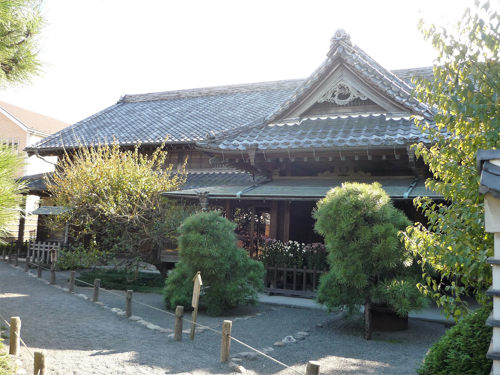 瓦屋根の大きな屋敷が、松や庭木の向こうに見える日野宿本陣の本陣屋敷
