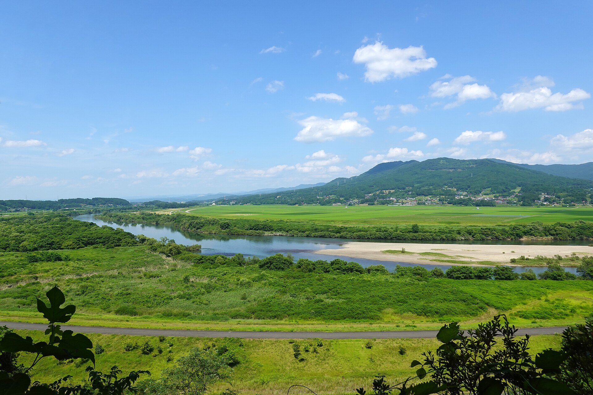 高館から見下ろす、緑の中を流れる北上川と、対岸の山並み