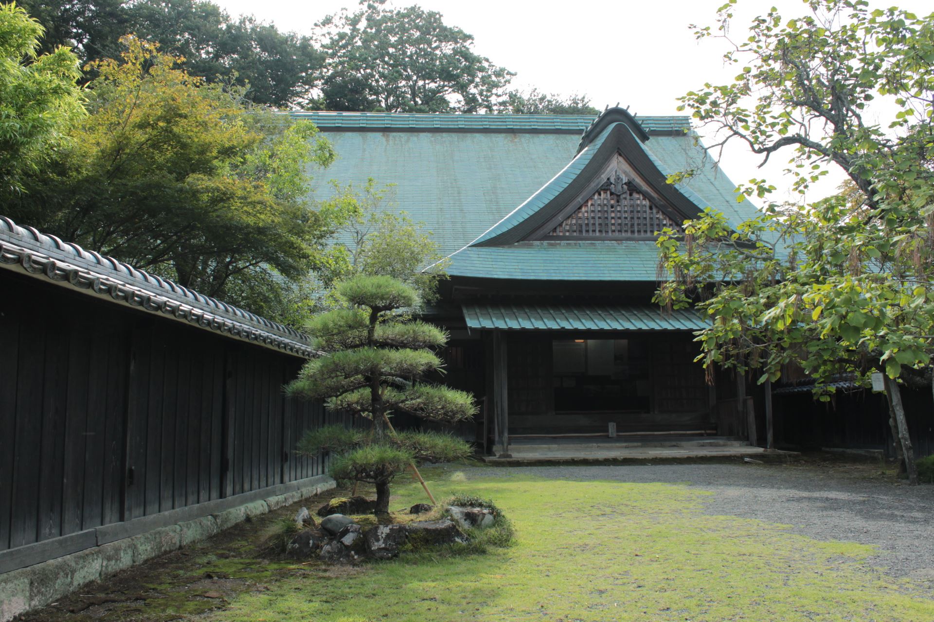 手前に松を植えた前庭があり、奥に大きな瓦屋根と破風の主屋が建つ江川邸