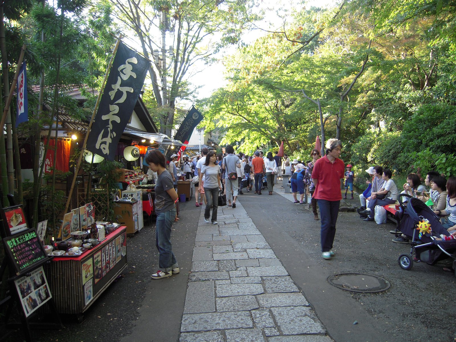 深大寺の参道。「手打そば」の幟を掲げた店が並び、石畳の道を人が行き交う