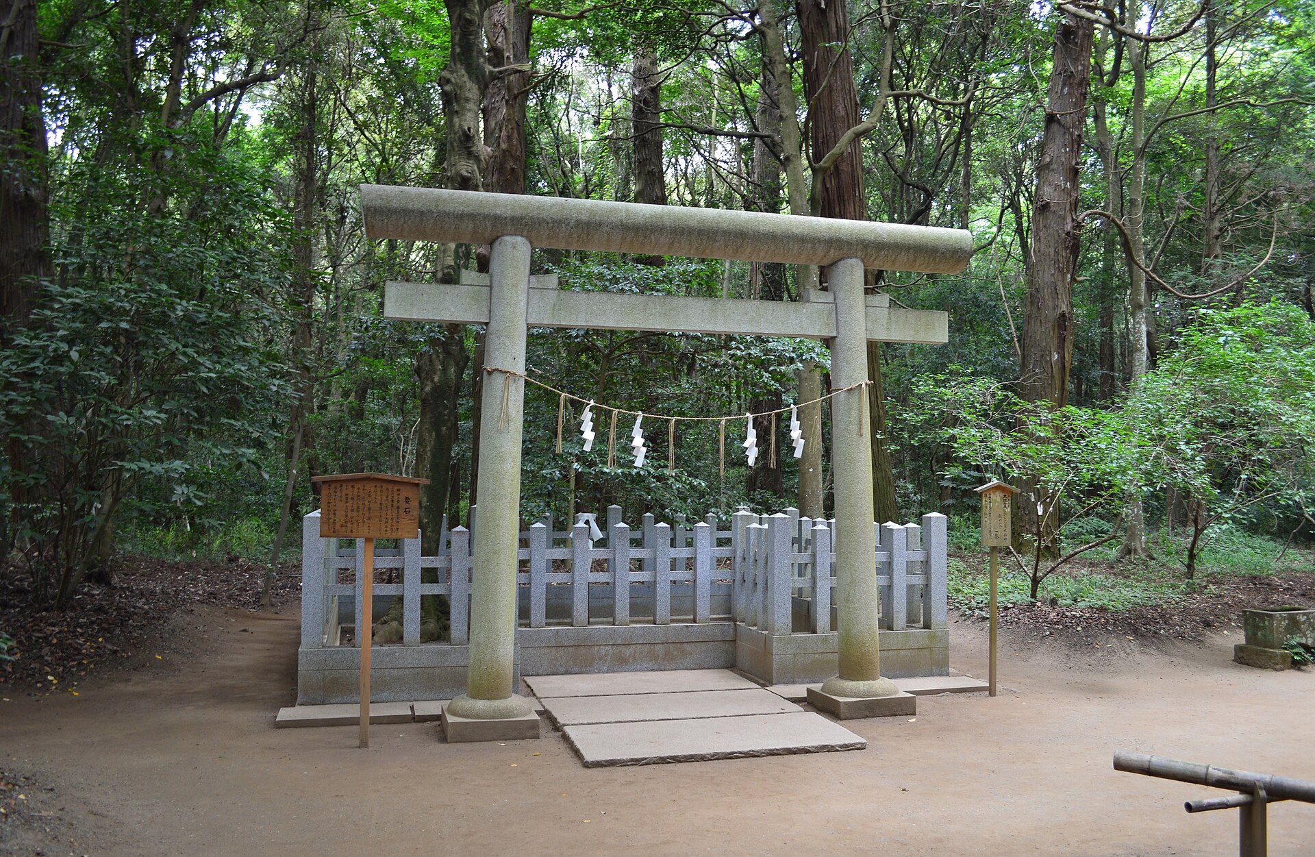 木立の中、石の鳥居と柵に囲まれた要石の場所