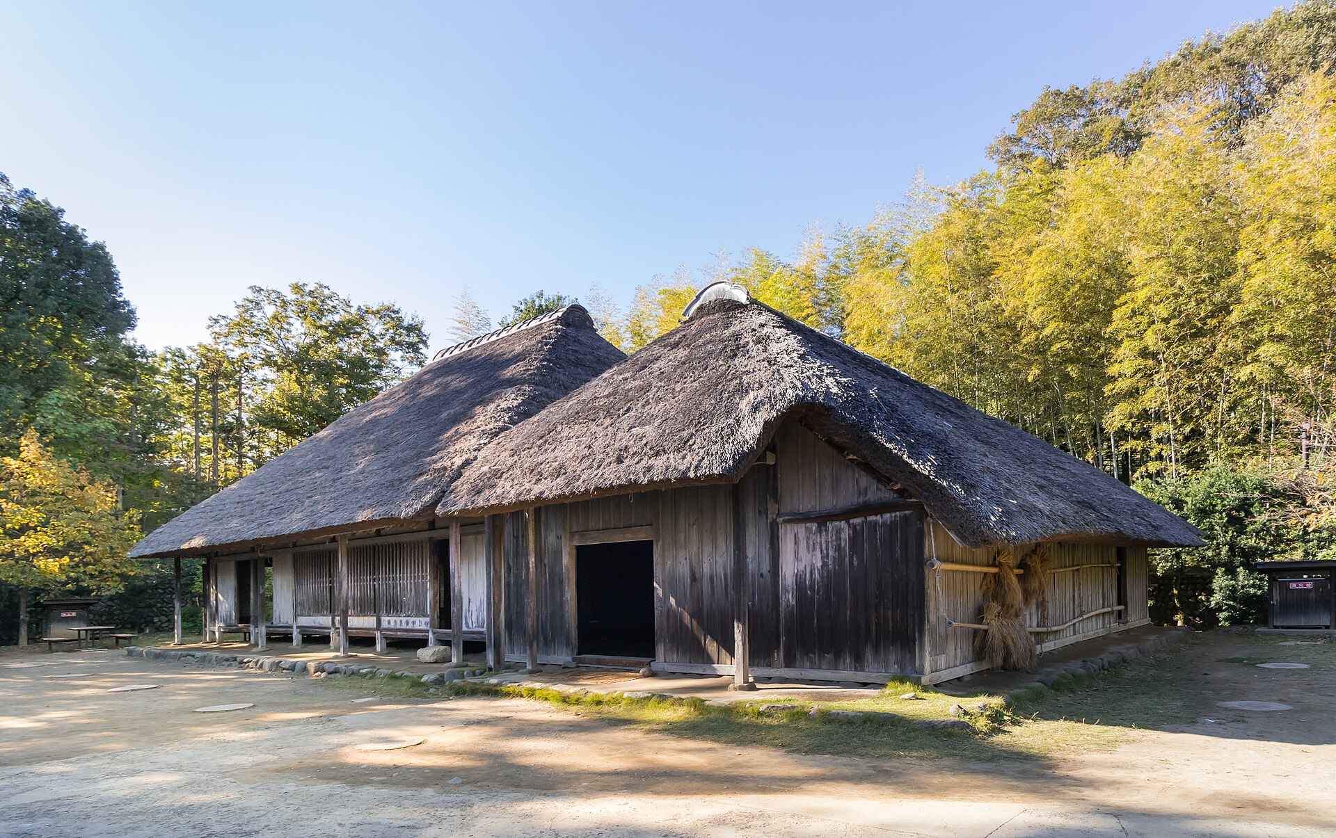 竹林を背に、茅葺き屋根が2つ連なる旧作田家住宅
