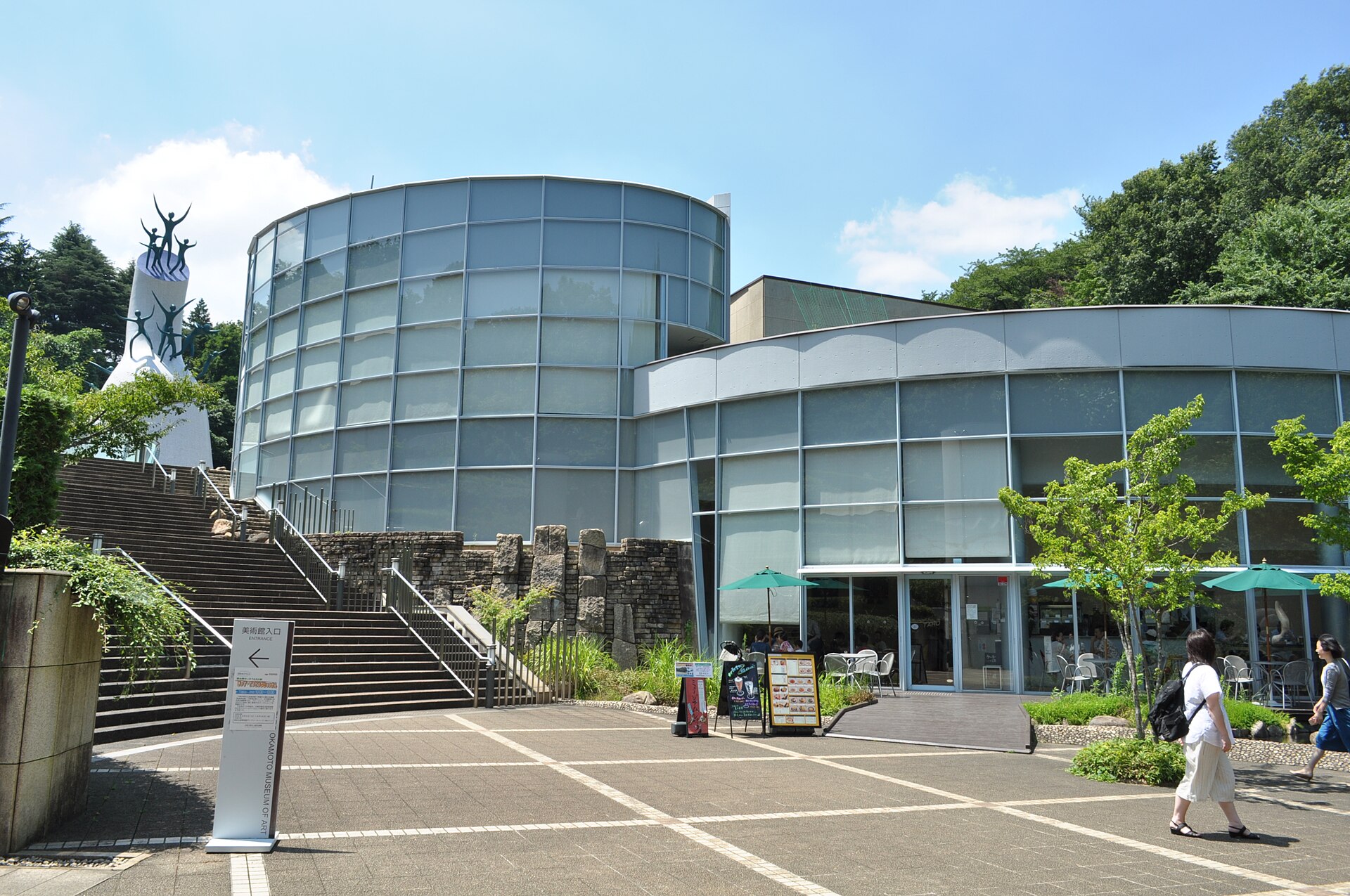 円筒形のガラス張りの建物と、母の塔が見える岡本太郎美術館