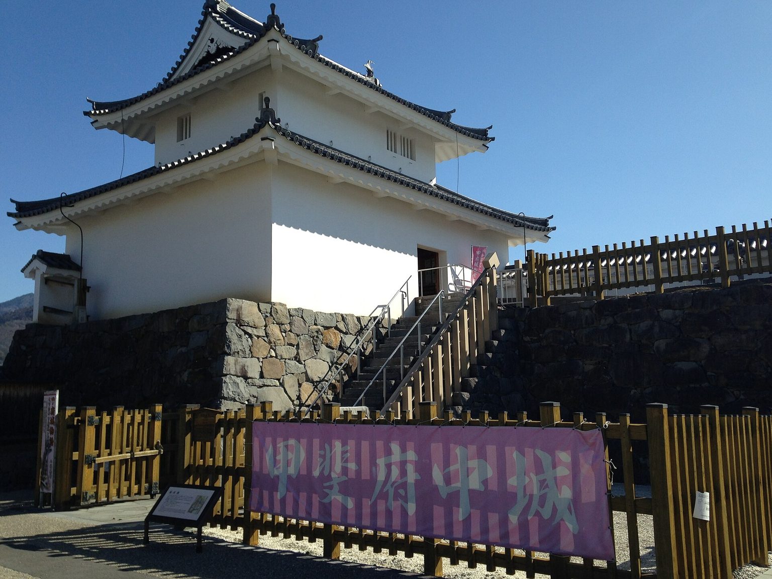 白い壁の稲荷櫓が石垣の上に建つ、舞鶴城公園の甲府城跡