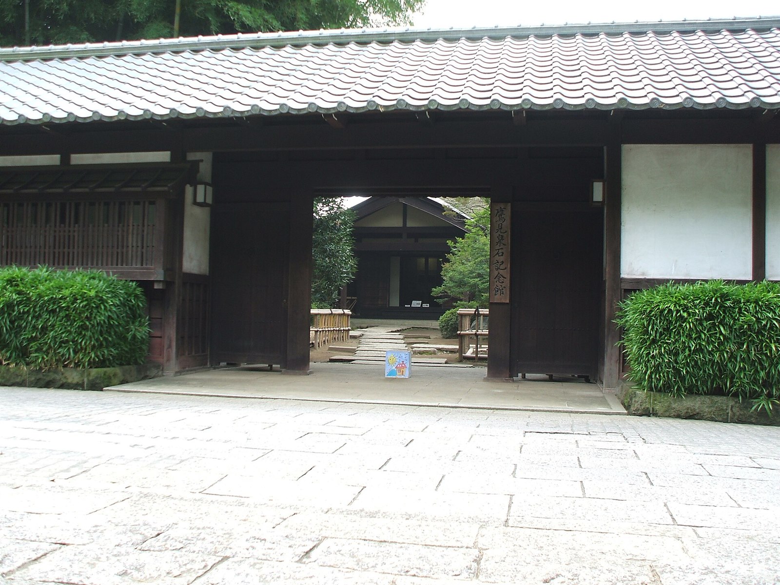 瓦屋根の門の奥に建物が見える、鷹見泉石記念館の長屋門
