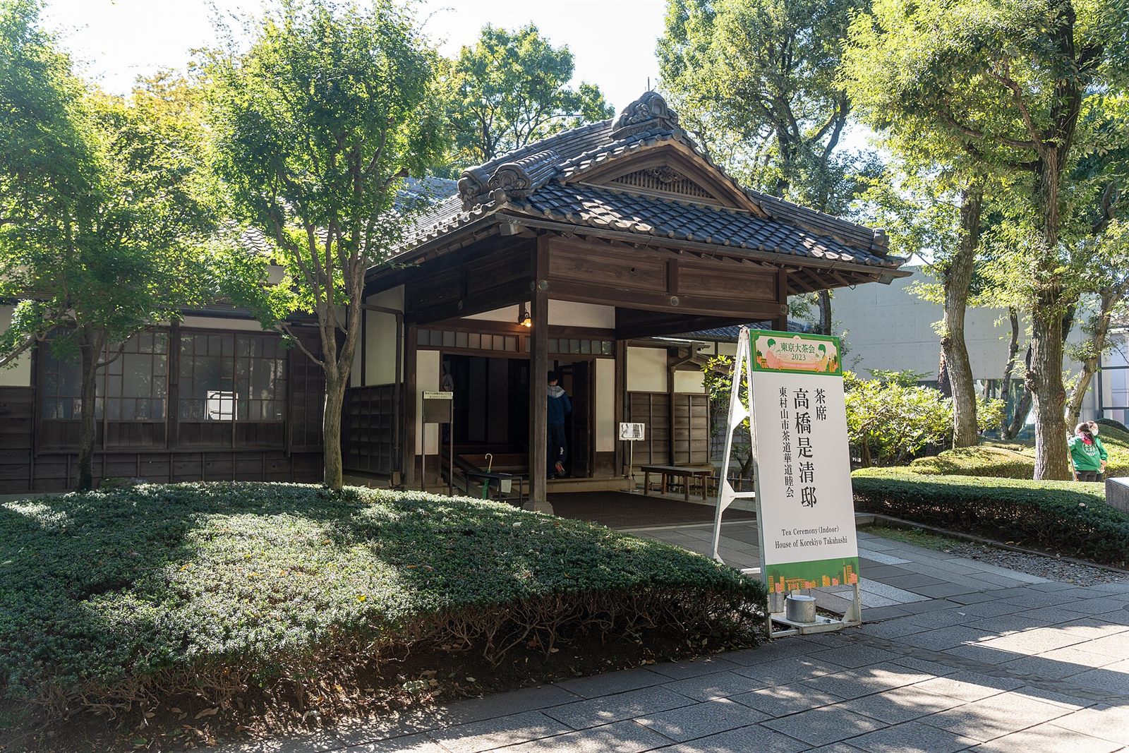 瓦屋根の玄関と、木々に囲まれた高橋是清邸