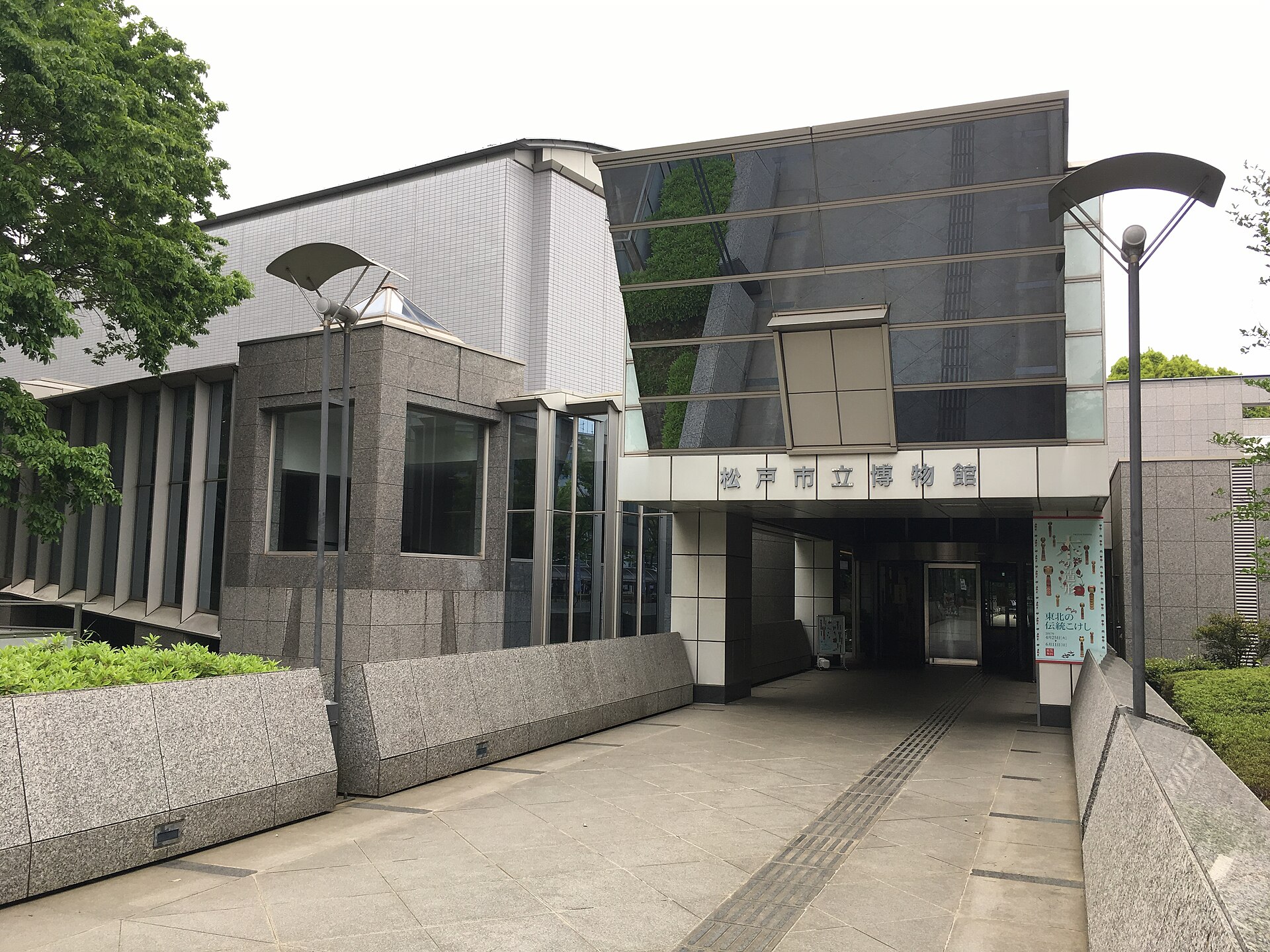 斜路の先にガラスの入口がある、松戸市立博物館