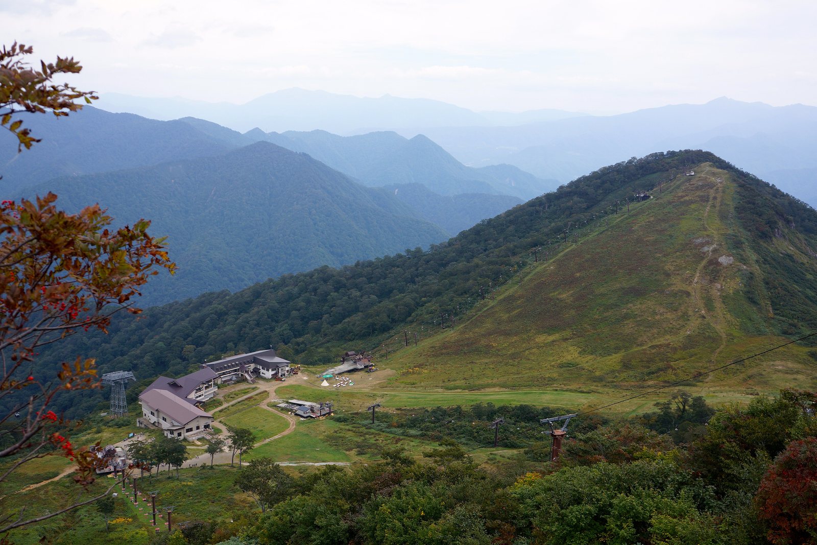緑の山並みを背に、山の中腹に建物が点在する天神平