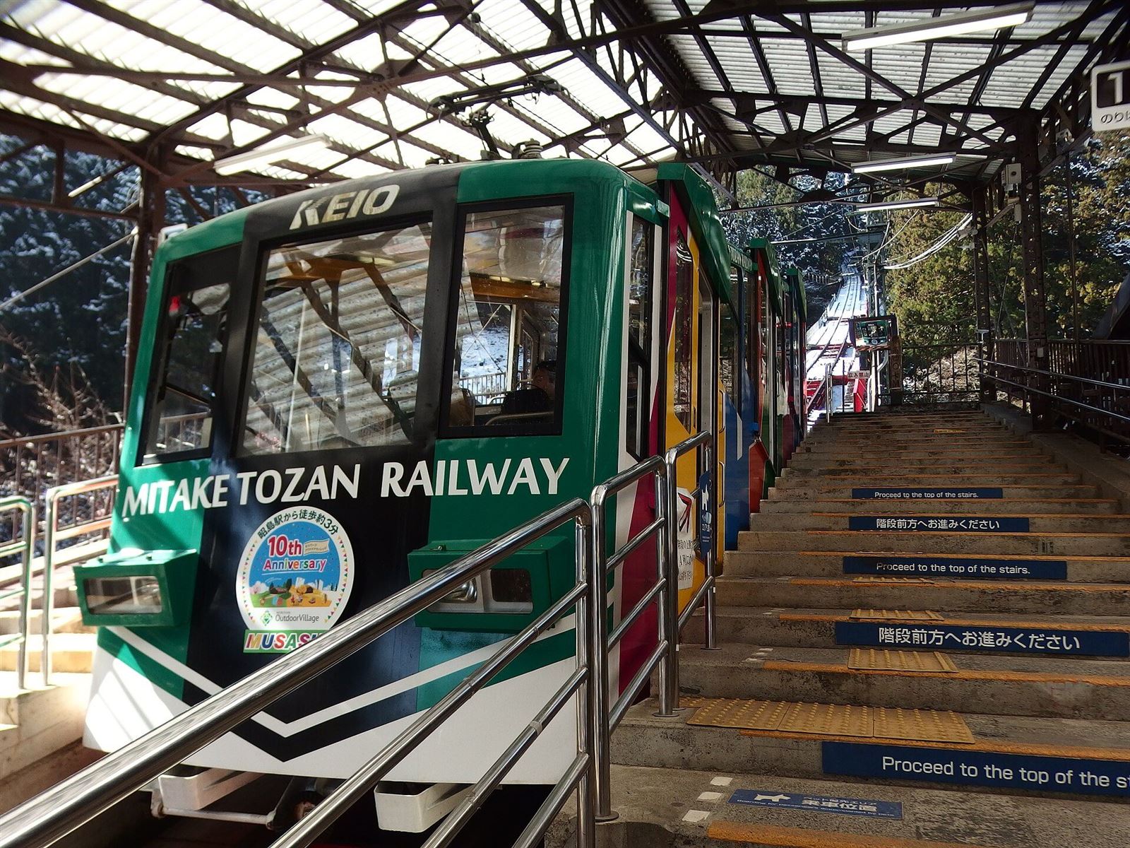 緑色の車体の御岳登山鉄道のケーブルカーが、駅のホームに停まる