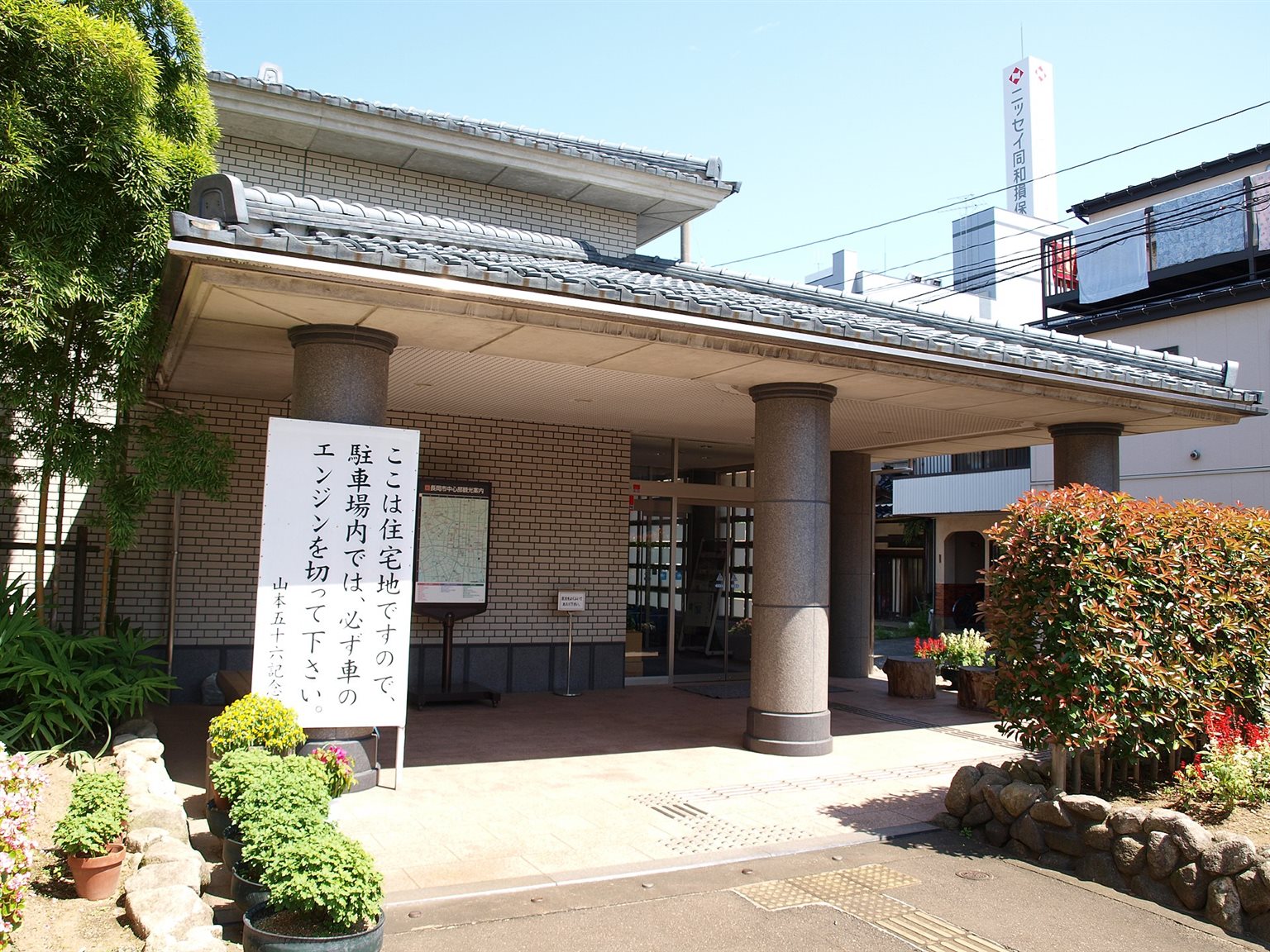 瓦屋根の庇の下に、石の柱が並ぶ山本五十六記念館の入口