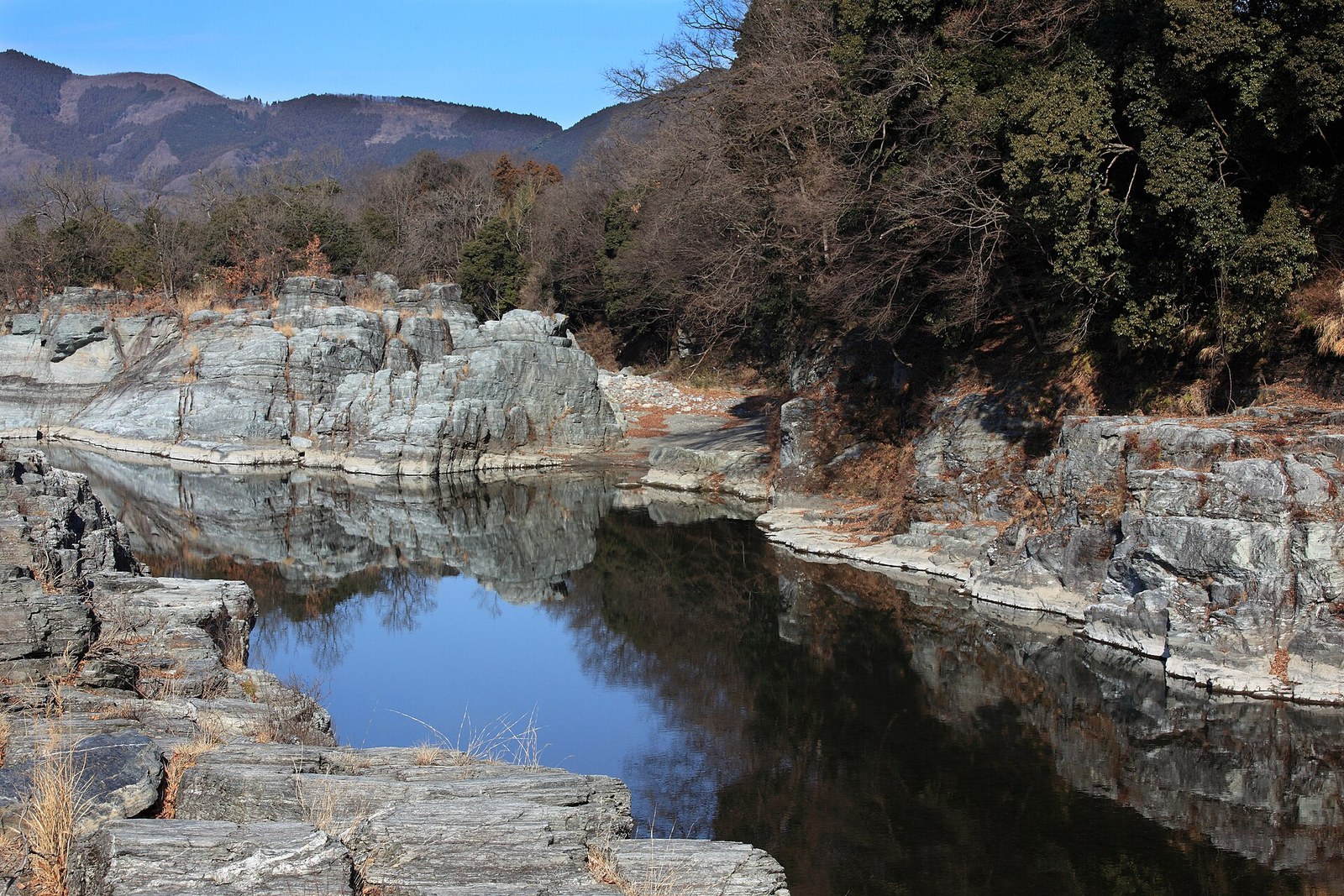 岩畳から見た荒川の瀞。層の重なった岩が水面に映っている