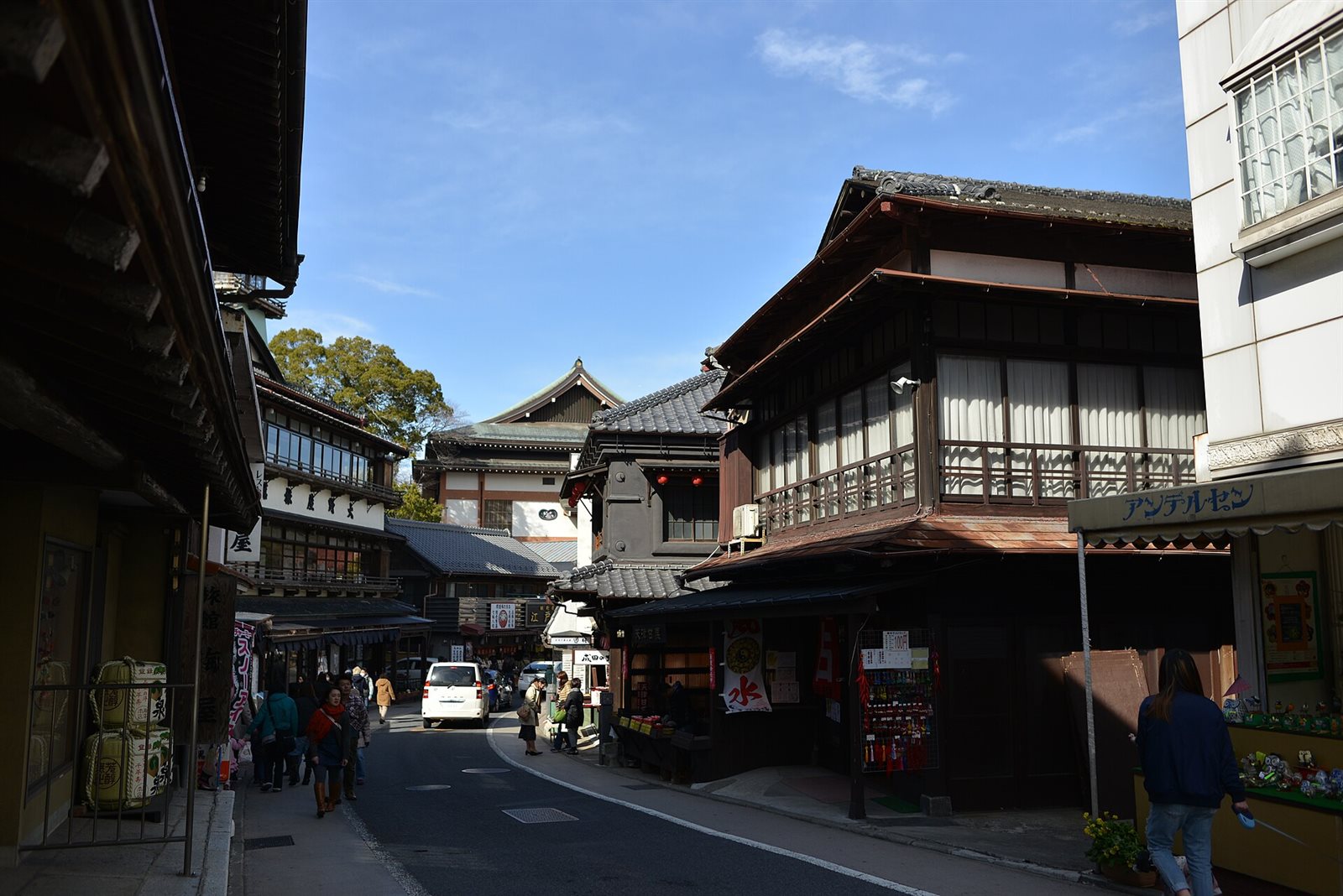 成田山表参道の坂道。両側に木造2階建ての旅館や商店が並び、ゆるやかに下る道を人が歩いている