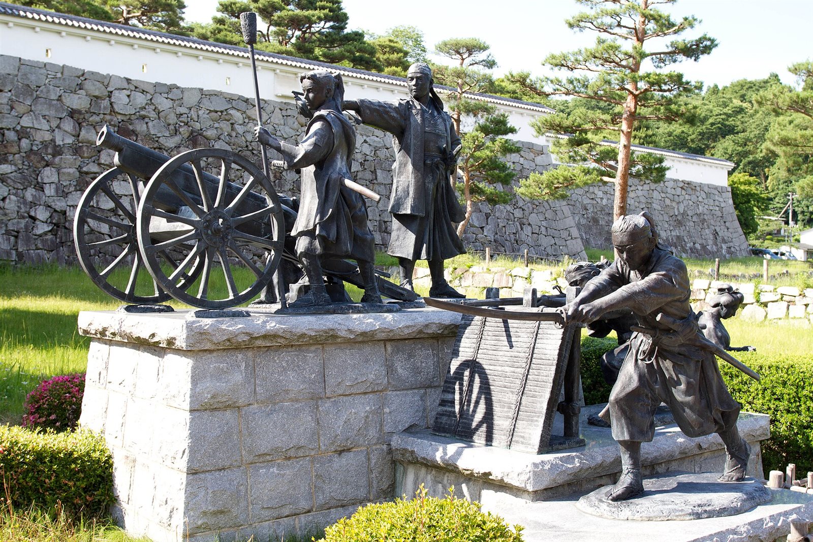 石垣を背に、大砲を囲んで立つ二本松少年隊の群像