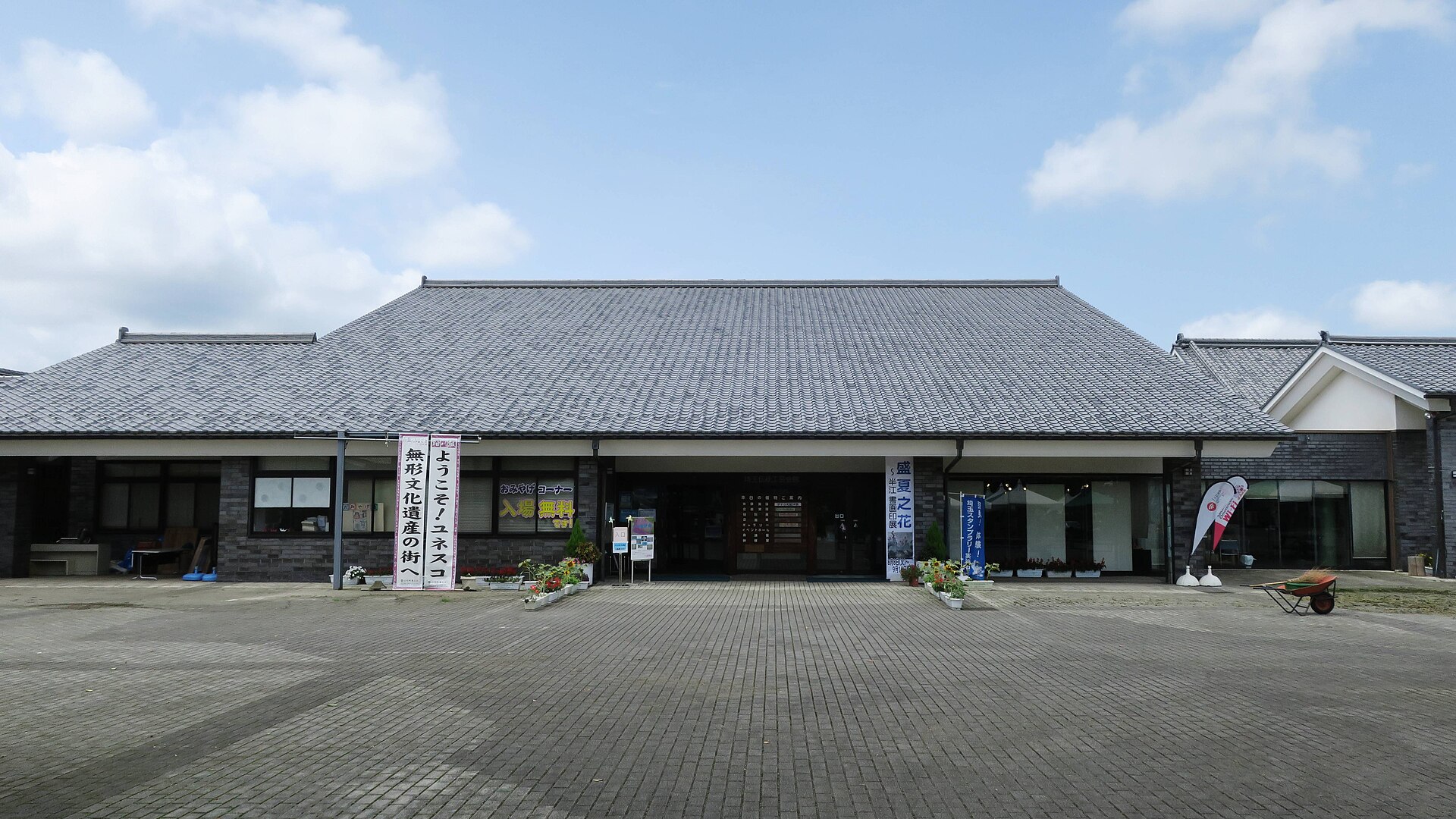 灰色の大きな瓦屋根をのせた、道の駅おがわまちの伝統工芸施設の入口