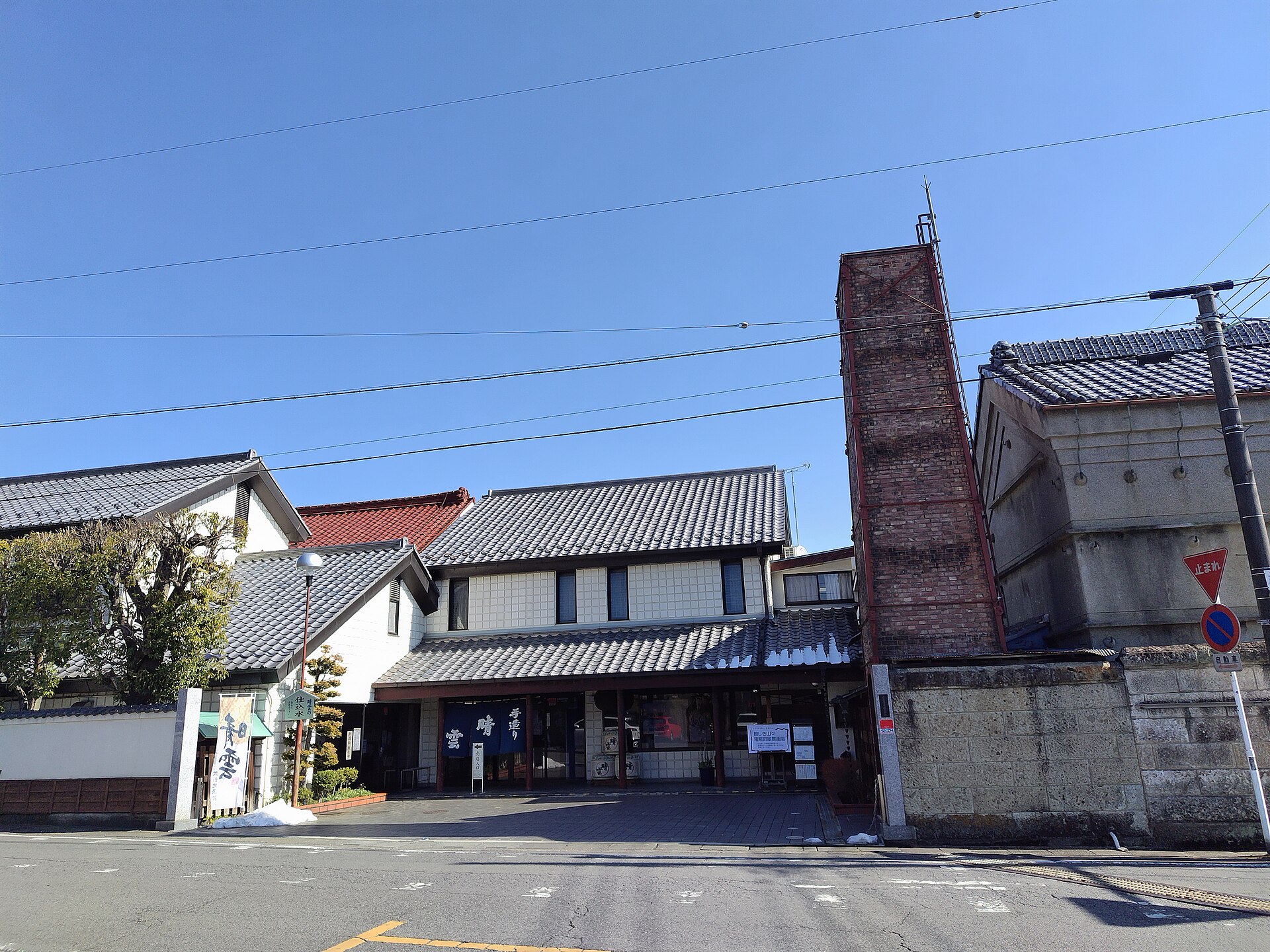 煉瓦の煙突と白壁の店舗が並ぶ、小川町の晴雲酒造の外観