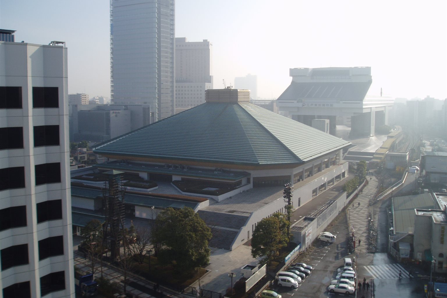 緑の屋根の両国国技館と、奥に見える江戸東京博物館を高い所から写した景色