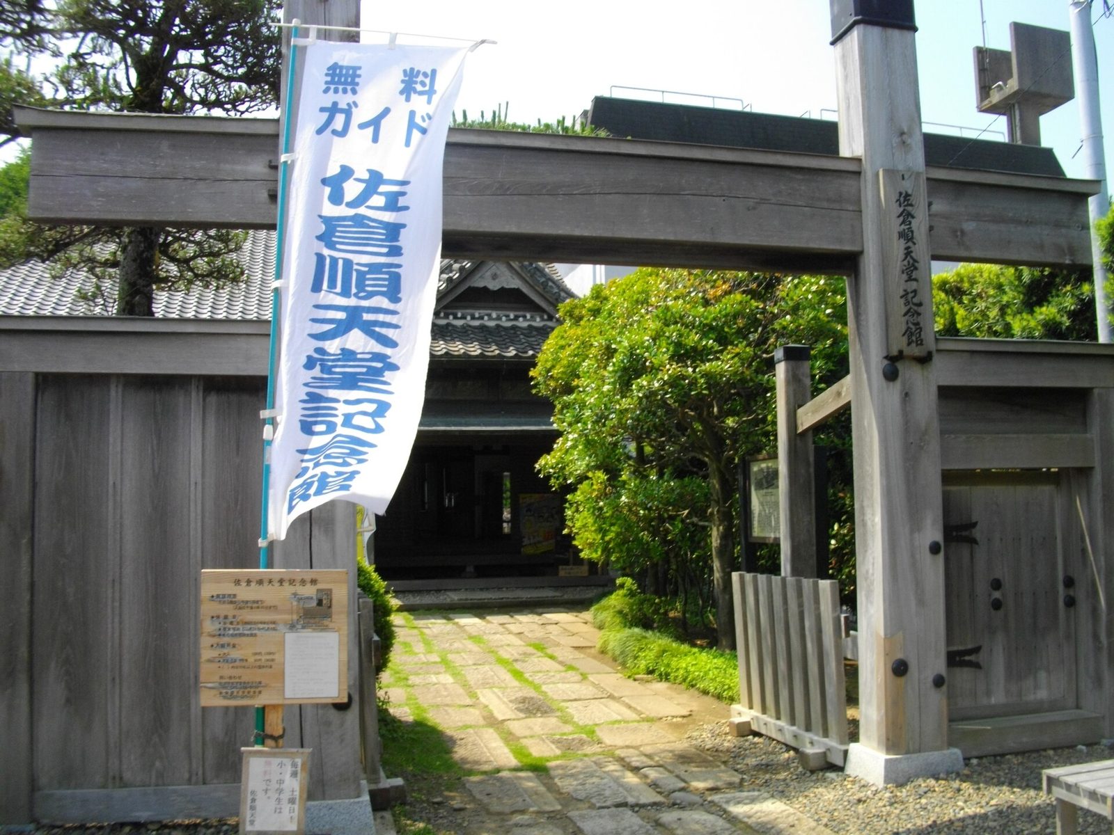 木の柱の門の奥に、記念館の建物が見える佐倉順天堂記念館の入口