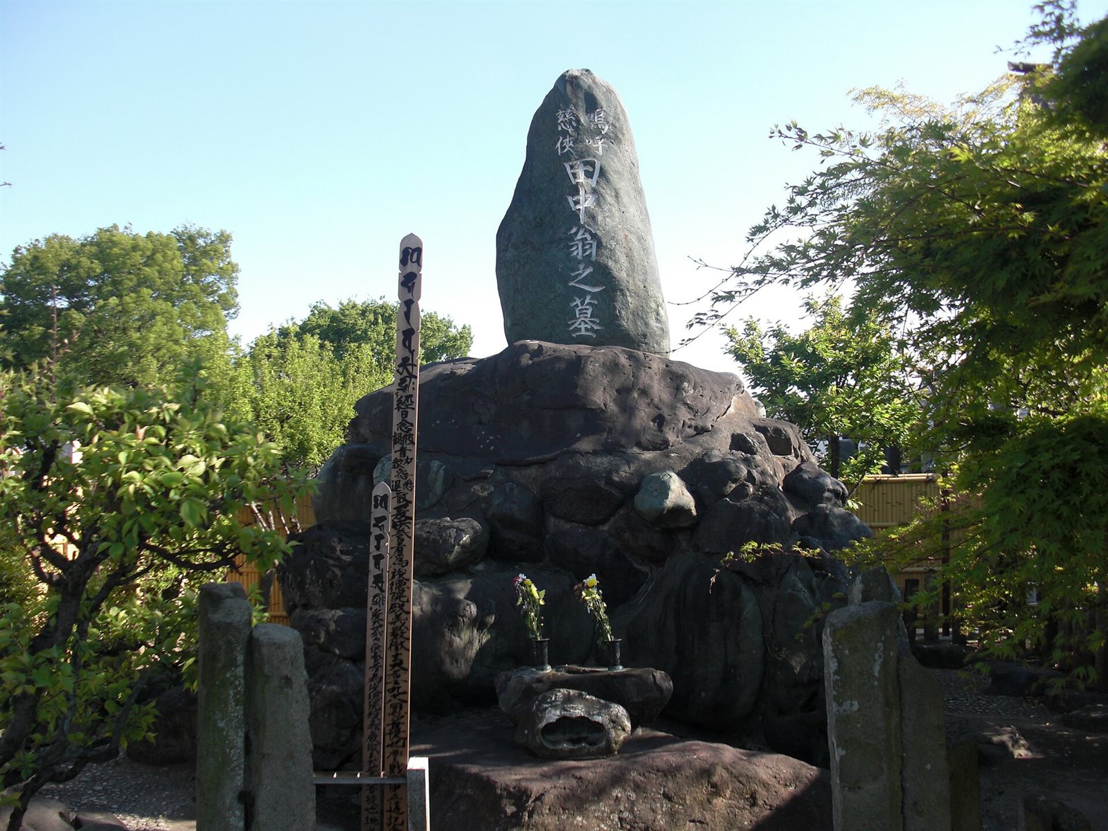 大きな石の上に「田中翁之墓」と刻まれた石碑が立つ田中正造の墓所
