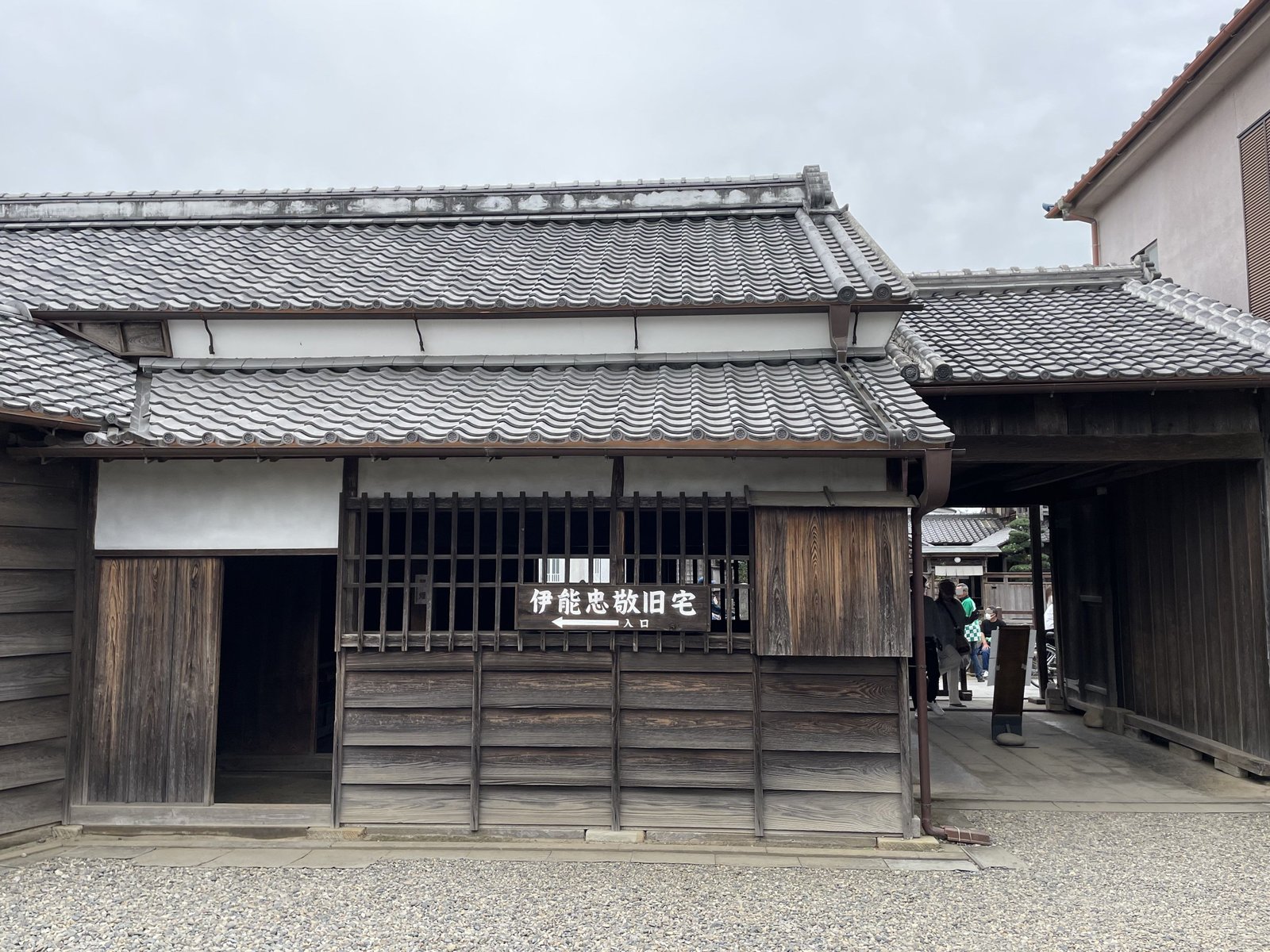 伊能忠敬旧宅の店舗。瓦屋根の木造の建物に格子窓があり、「伊能忠敬旧宅 入口」と書かれた木の看板が掛かっている