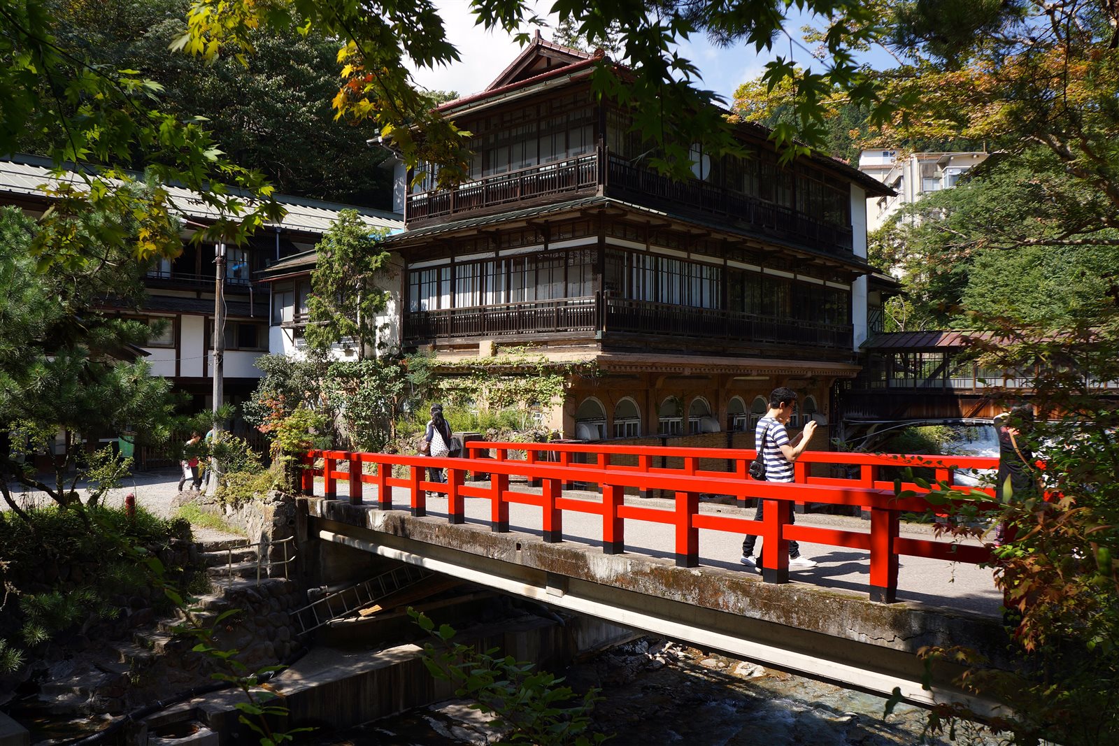 朱塗りの慶雲橋の向こうに、三層の木造の積善館本館が建つ