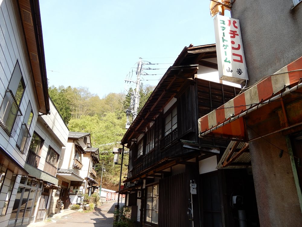 木造の古い建物と宿が軒を寄せ合う、四万温泉の坂道