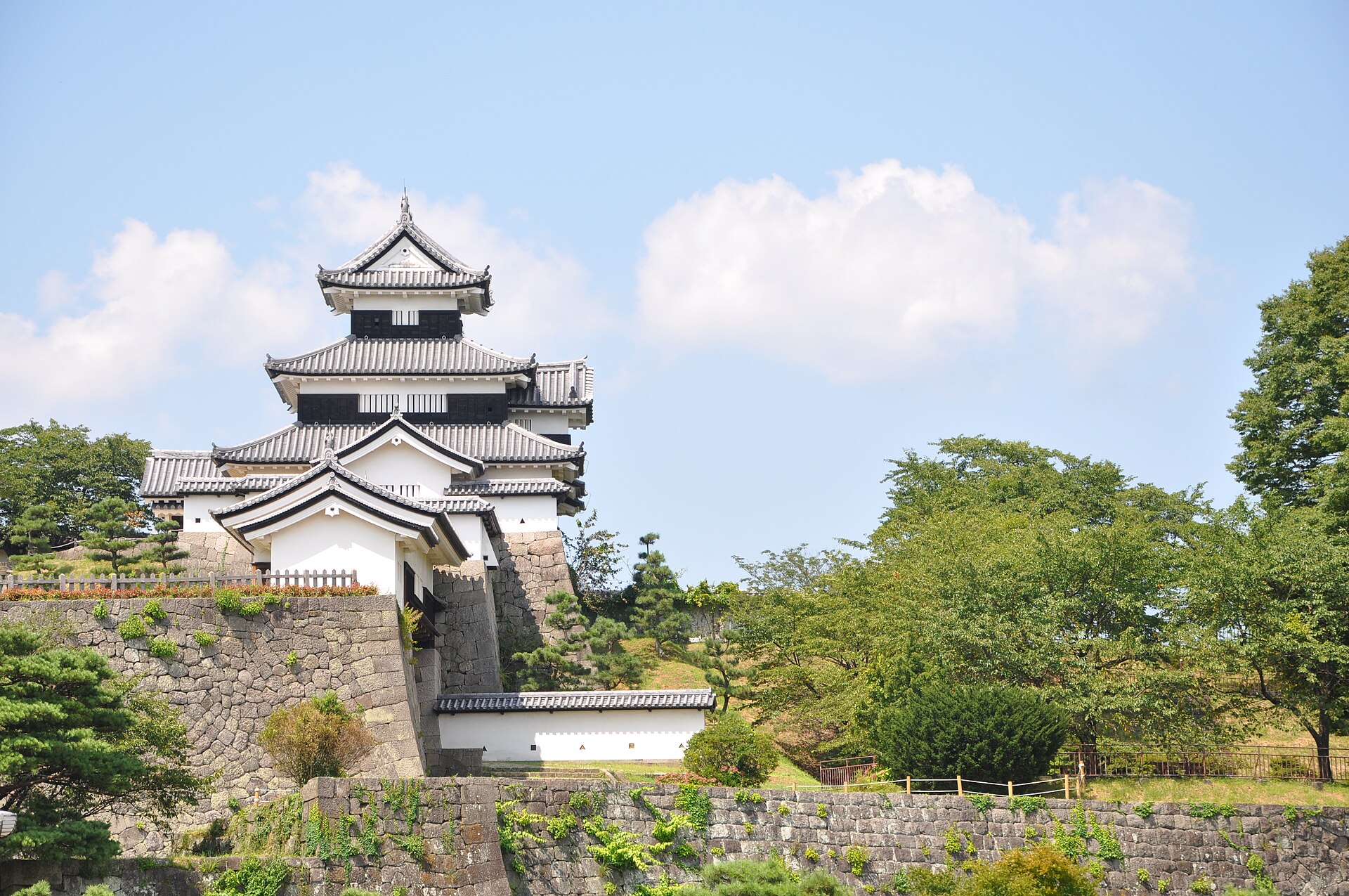 石垣の上に、白壁と瓦屋根の三重櫓が建つ小峰城