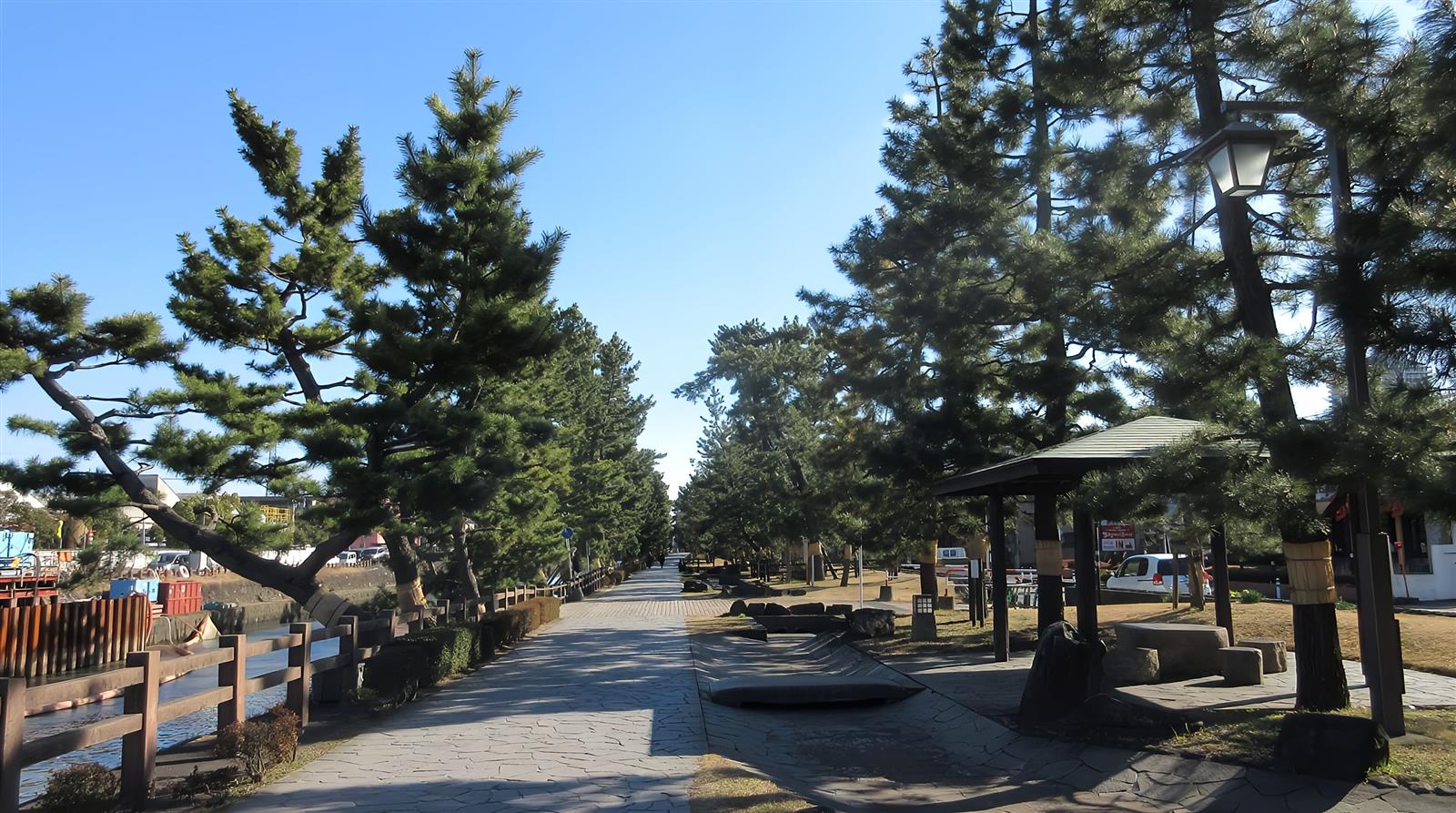 石畳の遊歩道の脇に、松が並び、東屋のある広場がある草加松原