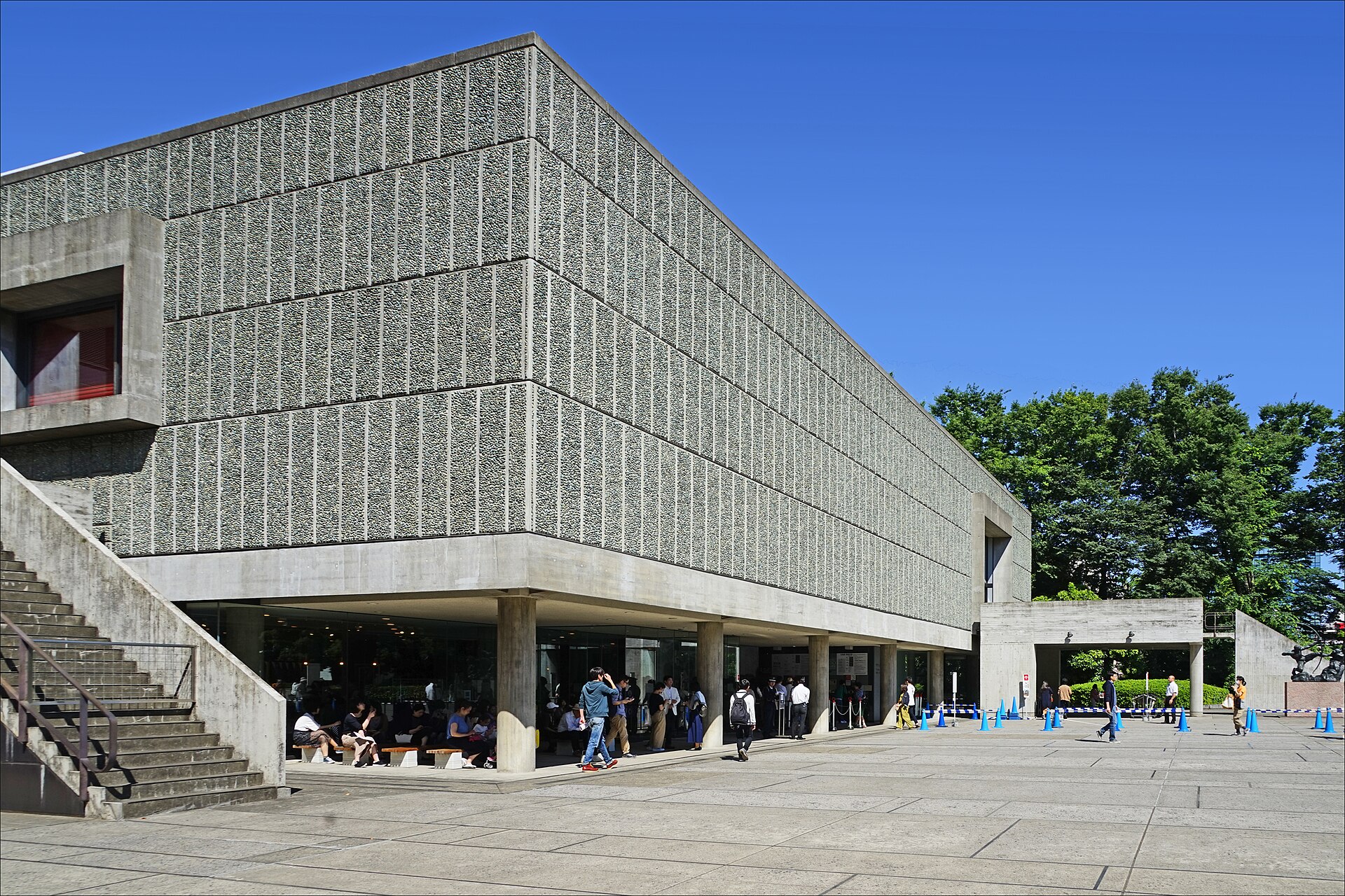 青空の下、柱の上に載る、小石を埋め込んだ壁面の箱型の国立西洋美術館本館