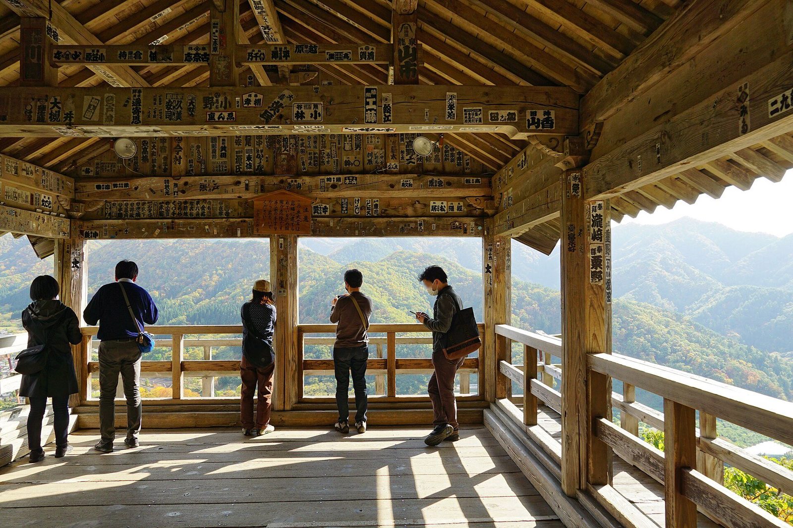 五大堂の舞台から、谷の向こうの山並みを眺める参拝者