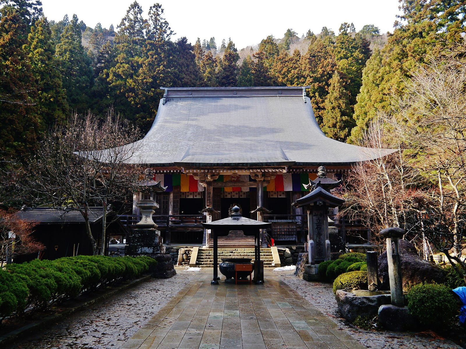 杉の木立を背に、色とりどりの幕を掛けた根本中堂の正面と参道