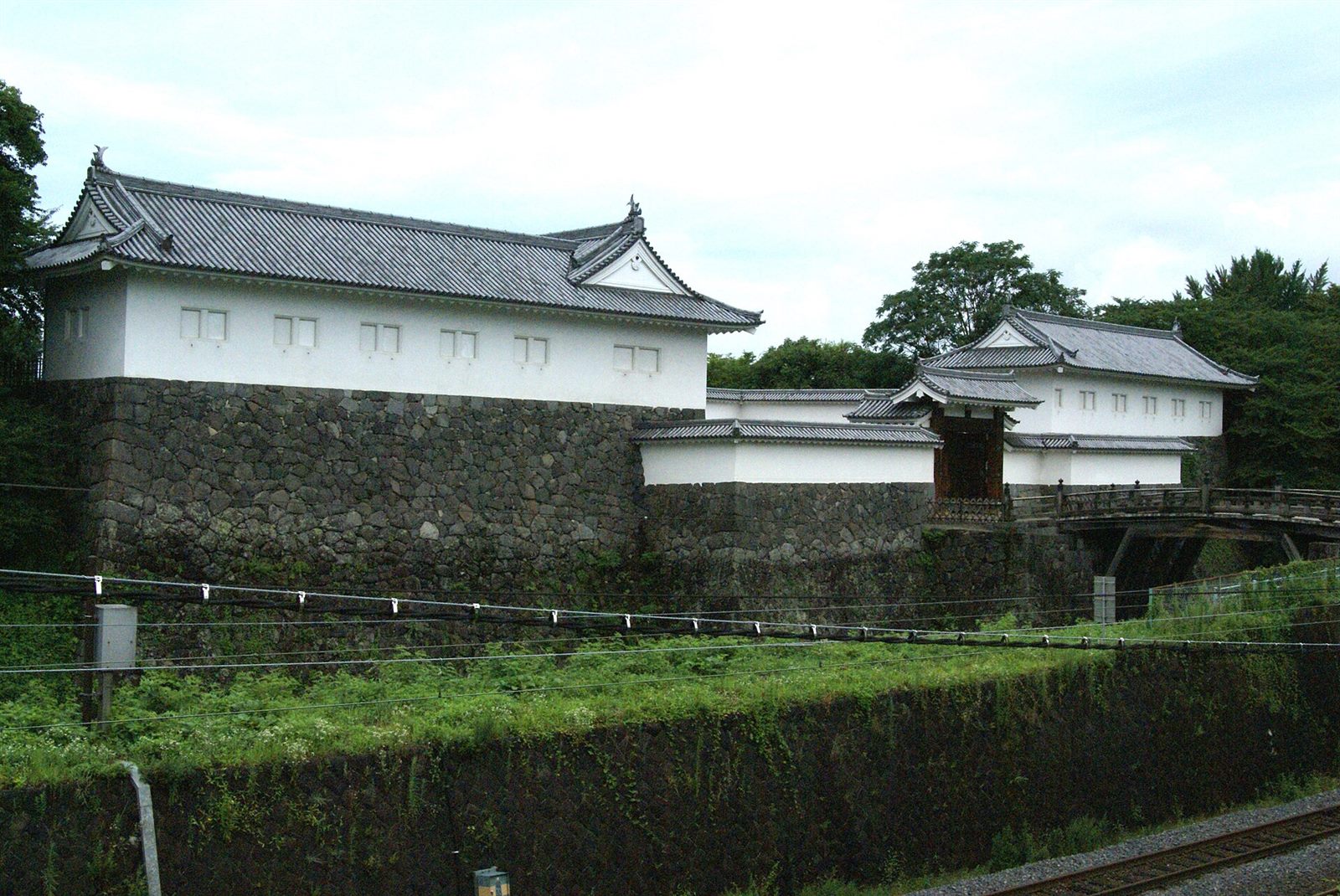 白い壁の櫓と石垣、木の橋のかかった二ノ丸東大手門が堀の向こうに見える