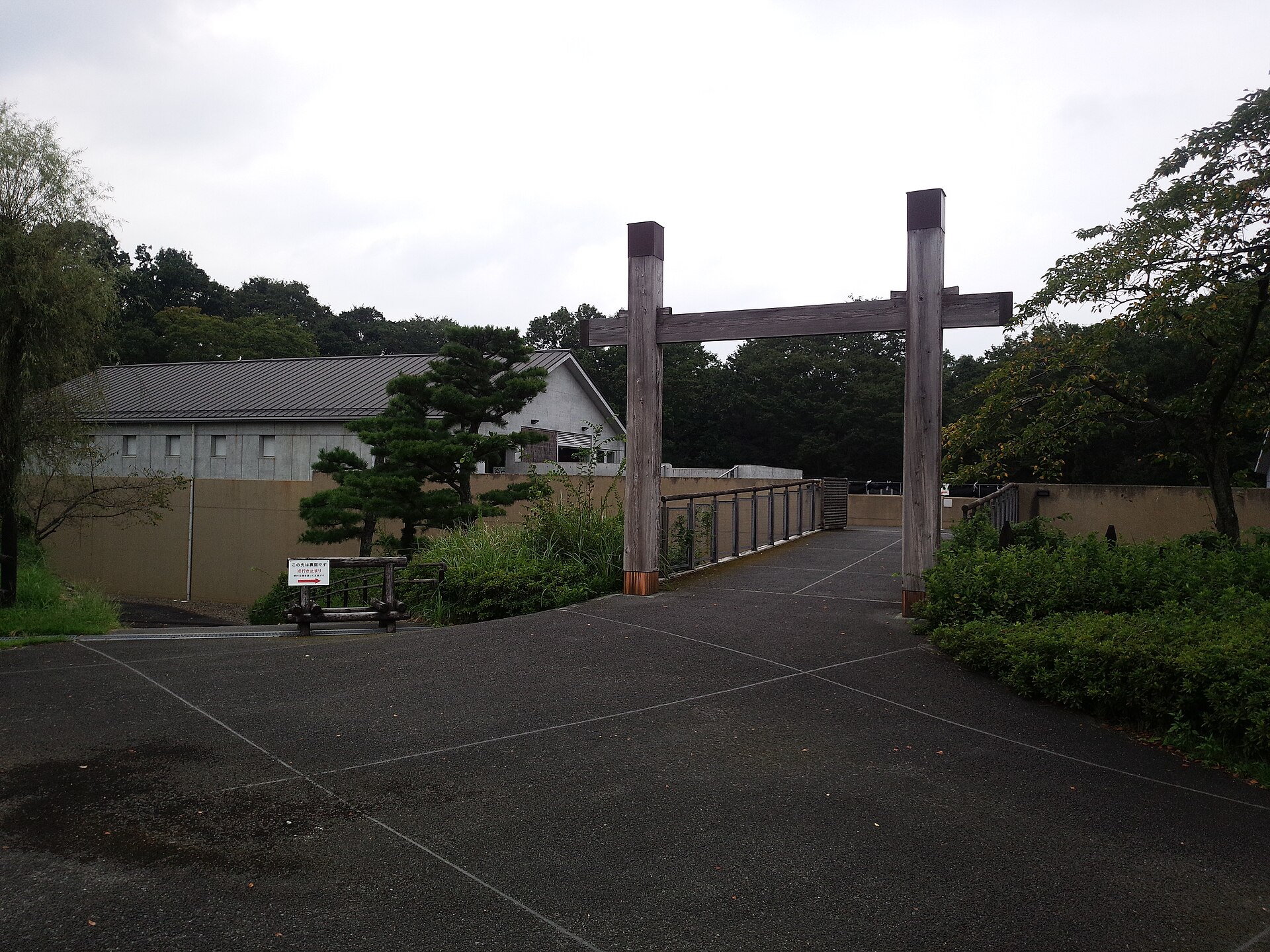 木の柱が立つ入口の先に見える、鉢形城歴史館の建物