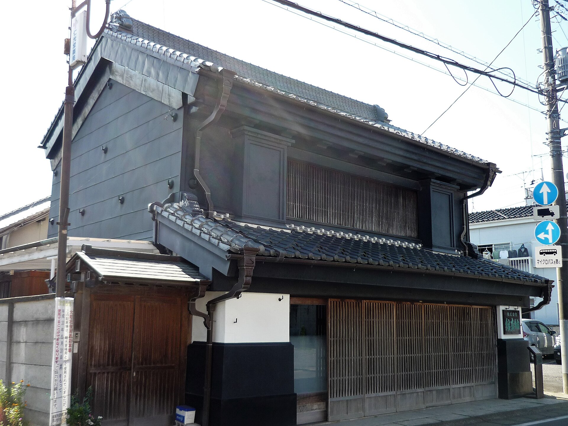 黒い板壁と瓦屋根、格子戸を備えた、結城の紬問屋の見世蔵