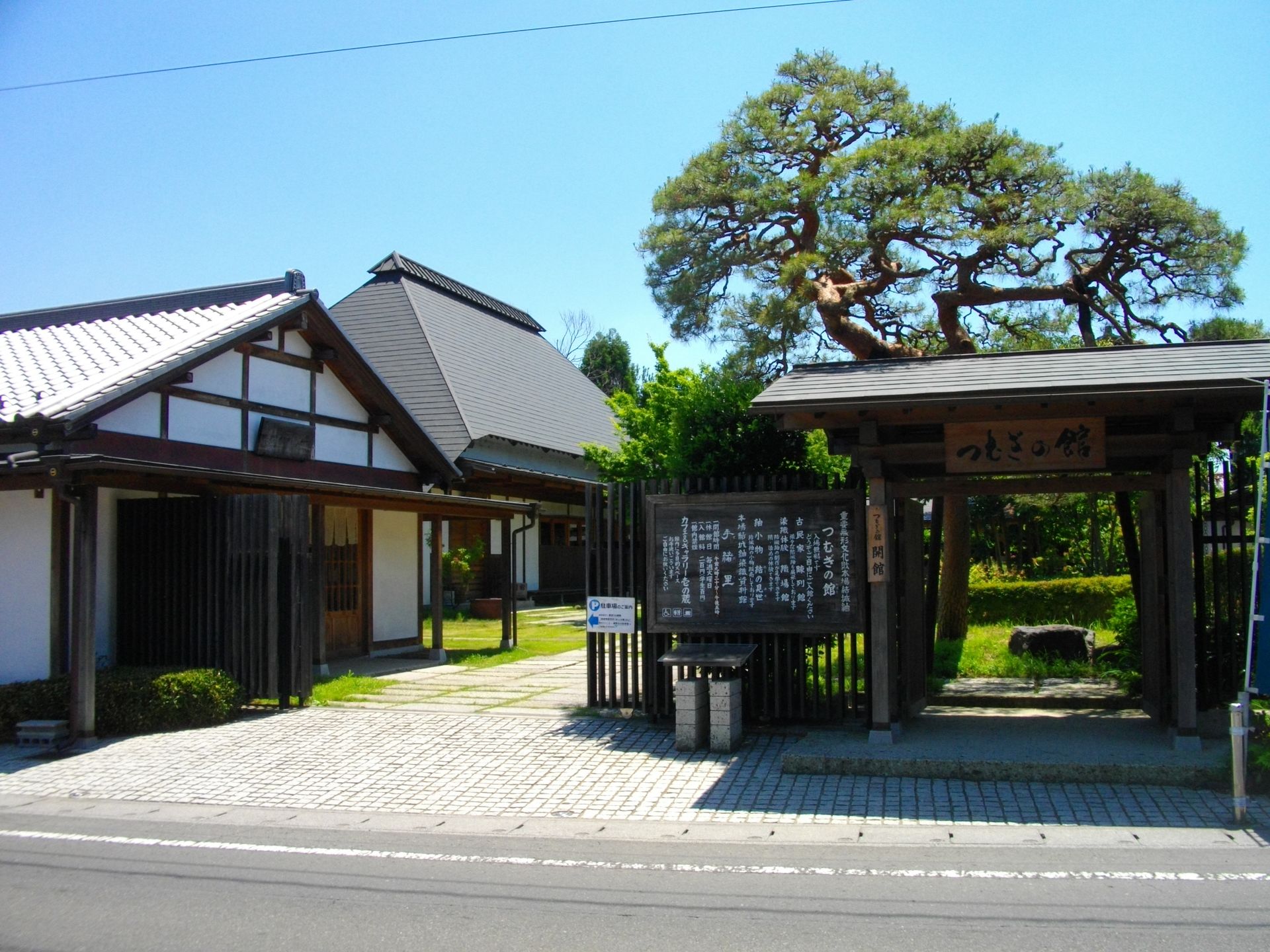 松の木と木の門が立つ、つむぎの館の入り口